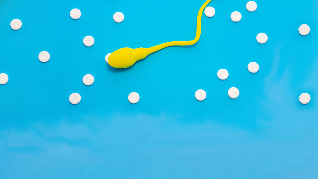 Illustration of a bright yellow sperm and round white pills on a bright blue background.