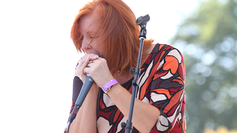 Geneva Red, jazz musician and blues singer, plays the harmonica on stage.