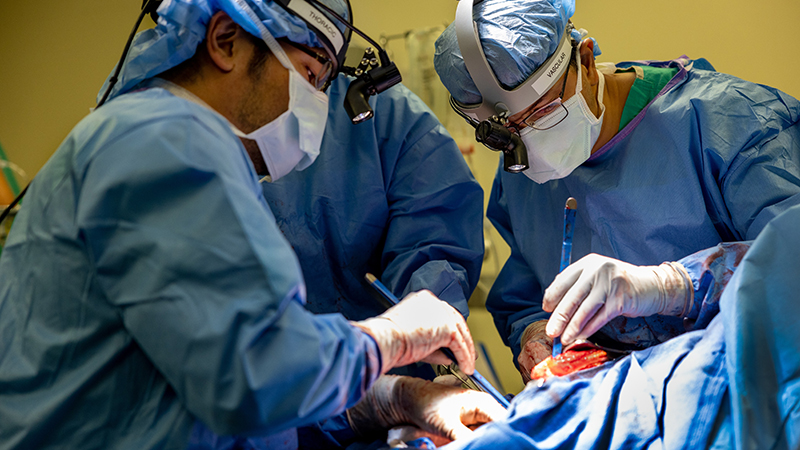 Closeup of surgeons performing a lung transplant on Art.