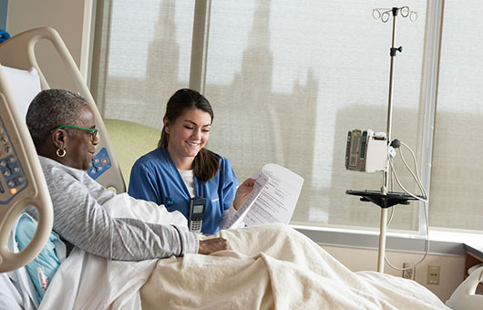 A cancer patient discussing her treatment plan with a nurse.