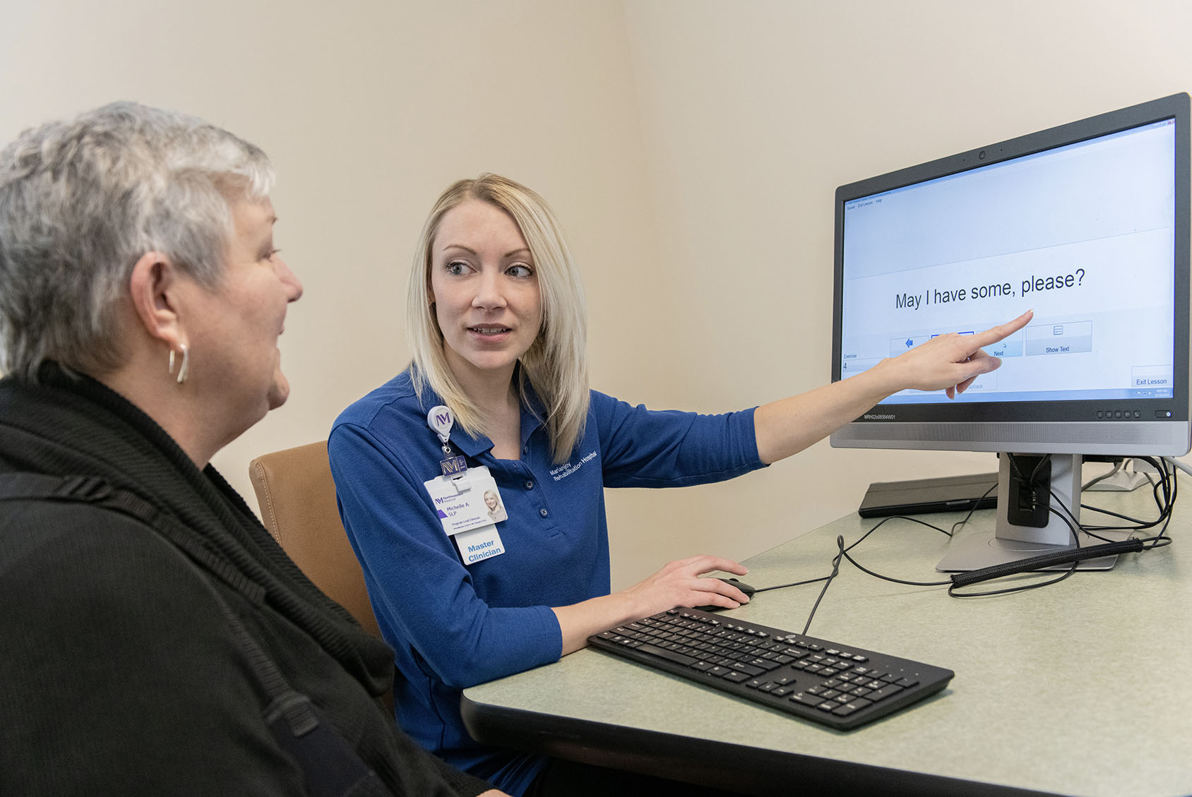 Clinician helping patient to read words on a screen.