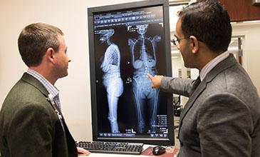 Northwestern Medicine doctors Tyler Koski and Alpesh Patel reviewing a patient's spinal injury.