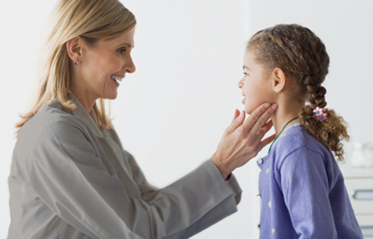 Doctor examining a young patient&#8217;s neck