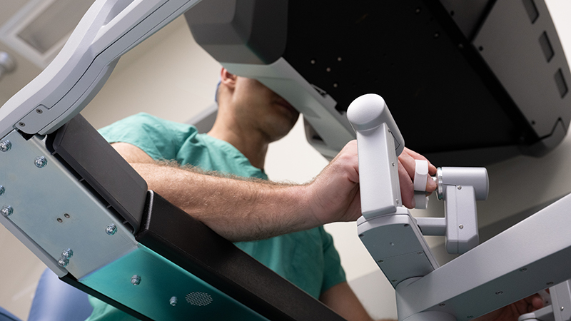 A surgeon using the hand controls of a da Vinci robot.