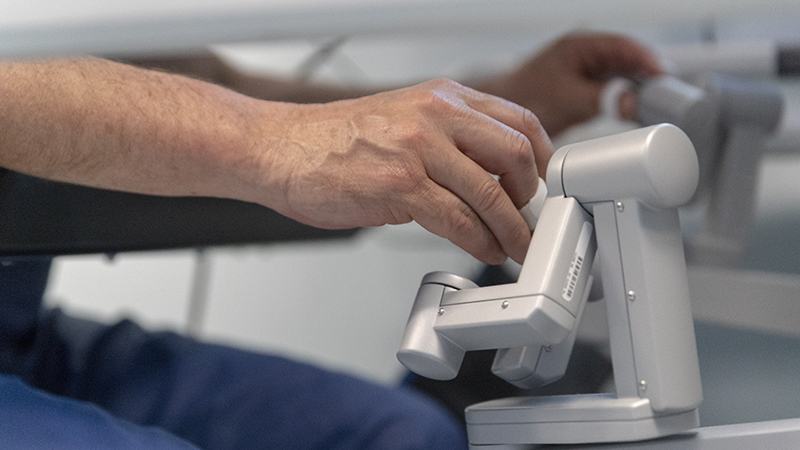 A hand on a piece of technology in a surgical room. 