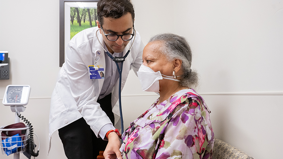 A physician examining a patient with a stethoscope
