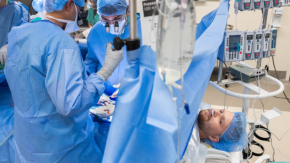 Surgeons performing a kidney transplant while patient is awake